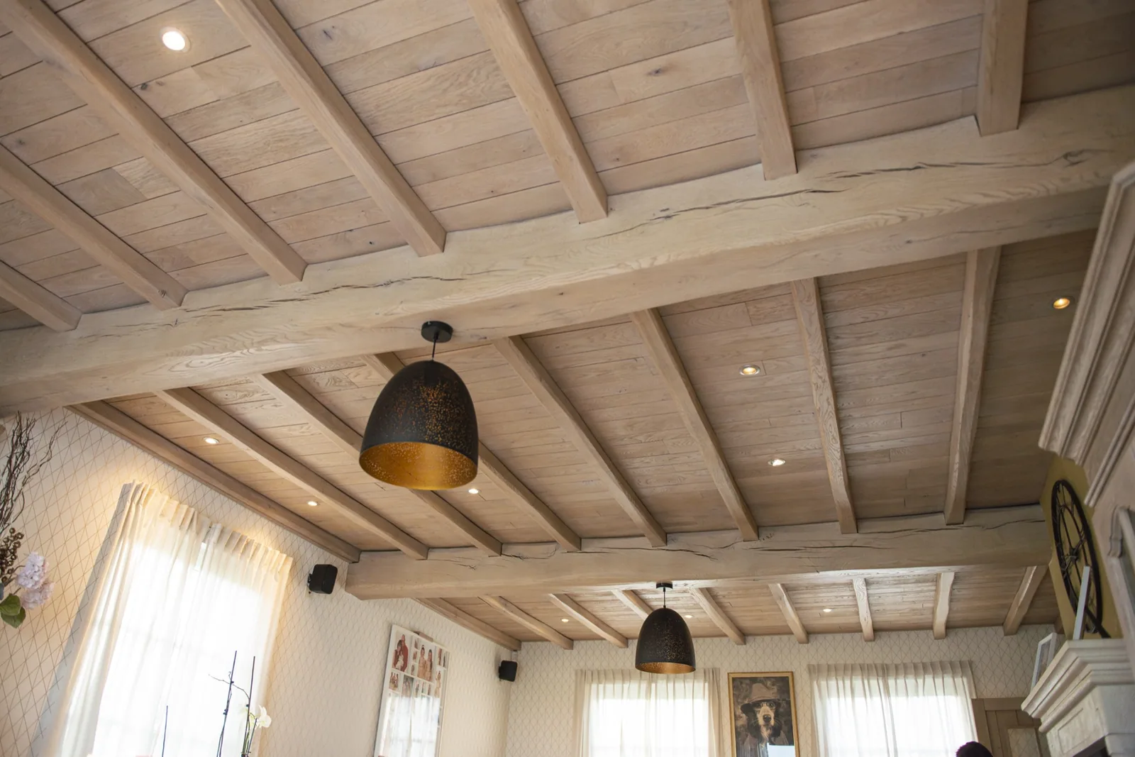 Woonkamer met gestraalde eiken plafondbalken en hanglampen