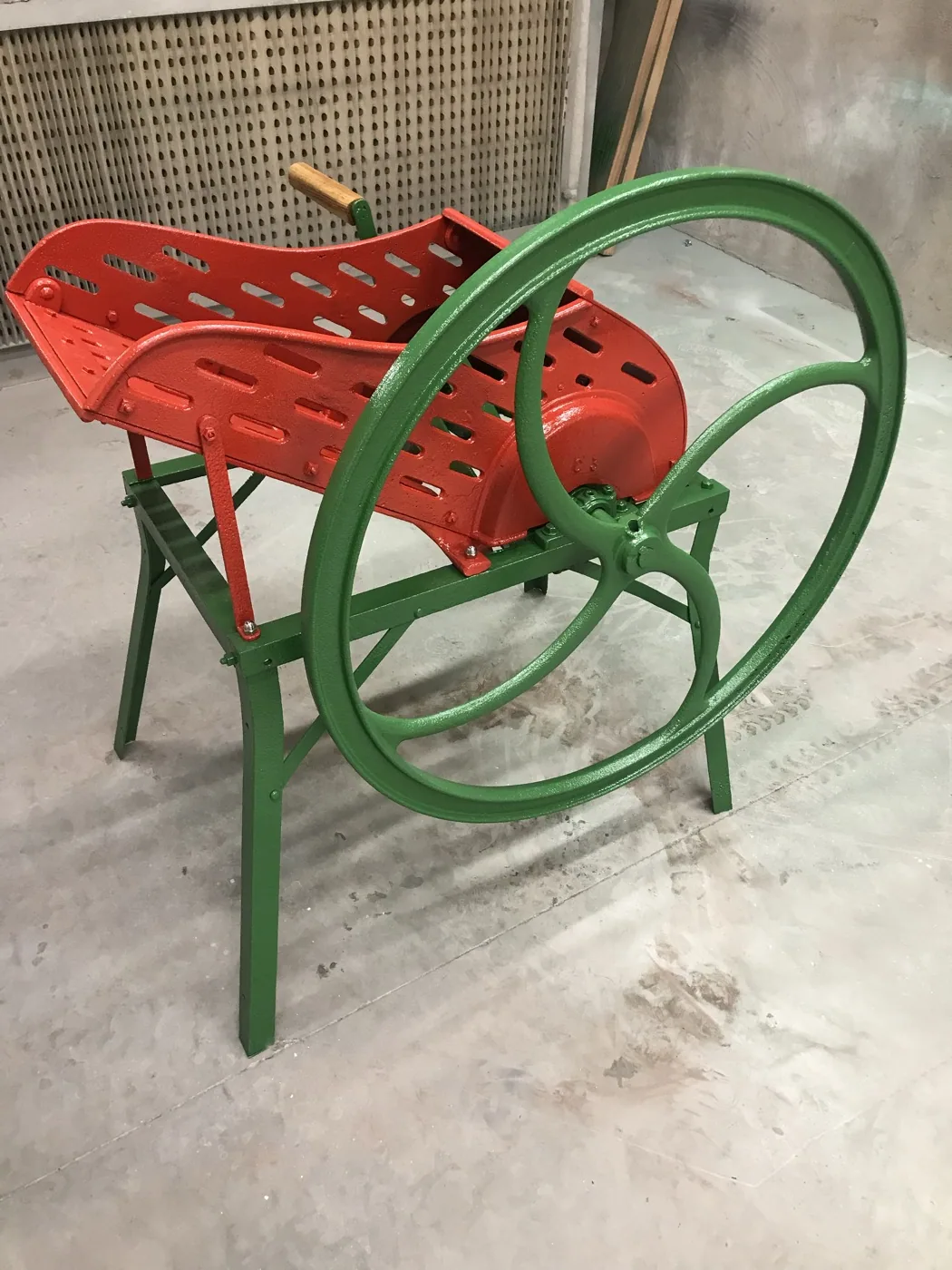 Gietijzeren tuinstoel met oude rode en groene verflaag voor het zandstralen