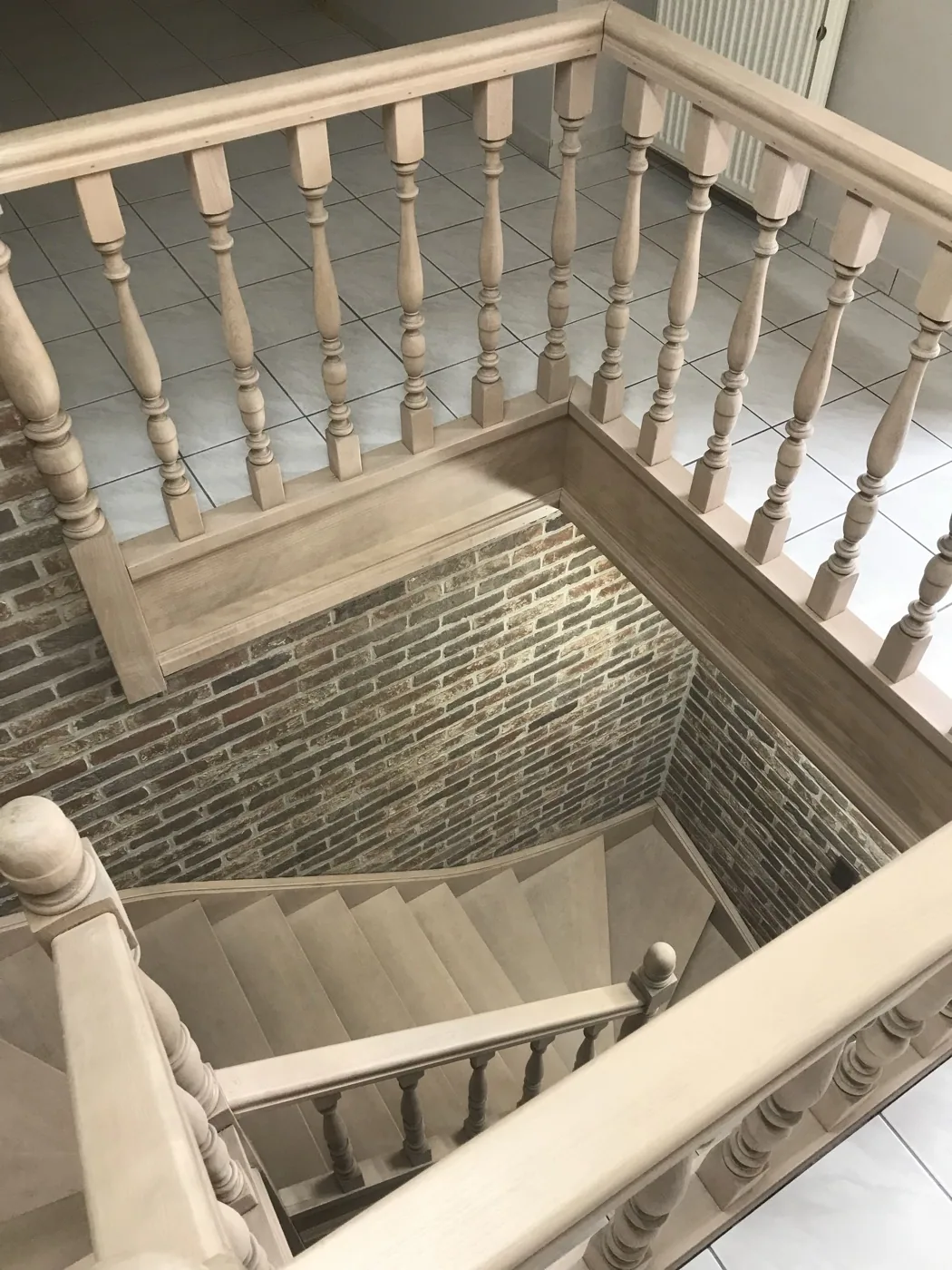 Trapgat met gestraalde houten balusters en leuning